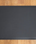 Black anti-fatigue mat included with 46 Inch Height Adjustable Standing Desk Converter, shown on wooden floor.