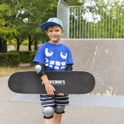 Child holding Minecraft Mob 31 Inch Skateboard With 9-Ply Maple Deck For Cruising, Carving, Tricks And Downhill at skate park