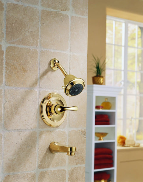Polished Brass Single Handle Faucet With WaterSense Certification mounted on a tiled wall, lever handle visible.
