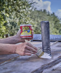 Liquid Rubber Coating Sealant being applied to metal surface with brush, 32 oz container held in hand, outdoor setting