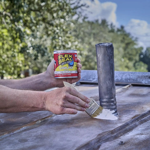 Liquid Rubber Coating Sealant being applied to metal surface with brush, 32 oz container held in hand, outdoor setting