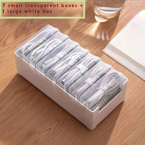Clear Cable Organizer Storage Box With 7 Wire Ties on wooden desk, holding cables neatly in transparent compartments.
