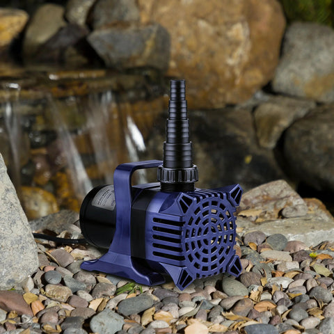 Blue submersible pond pump with top hose adapter and vented grille placed on rocks beside a waterfall.