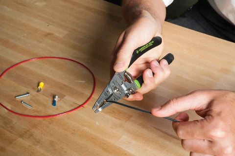 Using Stainless Steel Wire Stripper For 10-18 AWG Solid And 12-20 AWG Stranded on blue wire on table with connectors