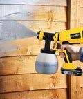 Person using Brushless HVLP Cordless Paint Sprayer 1200ML Cup With 4 Nozzles And 3 Spray Patterns That Works With 20V Batteries, Battery Not Included on wooden fence