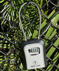Portable Key Lock Box With Cable Shackle And Wall Mount Waterproof Metal Key Safe For 4 Digit Resettable Code on fence