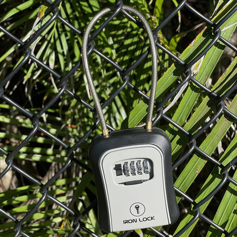 Portable Key Lock Box With Cable Shackle And Wall Mount Waterproof Metal Key Safe For 4 Digit Resettable Code on fence