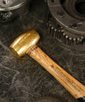 Non Sparking Brass Hammer 18 Inch 5 Pound USA Made With Wood Handle And Double Faced Head resting on industrial surface
