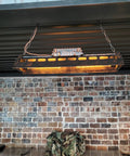 Rustic Farmhouse Chandelier 4 Light Industrial Pendant Lighting with adjustable height in a dining room setting against brick wall.