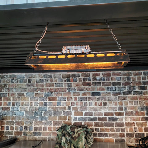 Rustic Farmhouse Chandelier 4 Light Industrial Pendant Lighting with adjustable height in a dining room setting against brick wall.