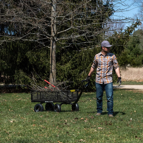 Man using Heavy-Duty Steel Utility Cart With 4 Cu Ft Bed And 900 LB Load Capacity, Black Towable Hauling Wagon With Removable Side Panels For Yard on grass.