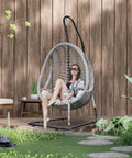 Woman sitting on Heavy Duty Hammock Chair Stand With Adjustable Steel Frame Built To Last, Weatherproof And Rust Resistant Swing Stand, 330 Lb Capacity, Portable For Indoor Outdoor Patio Or Tree, Lounger And Porch