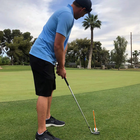 Golfer using Magnetic Golf Alignment Rods for Instant Swing Feedback on green, visualizing upright, flat, square lie angles, orange