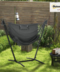 Outdoor setting featuring Patio Hammock Chair With Stand For Outdoor Chill And Cozy Lounging Heavy Duty Hanging Swing With Side Pocket And Headrest Weatherproof Fabric Boho Tassels Easy Assembly Dark Gray.