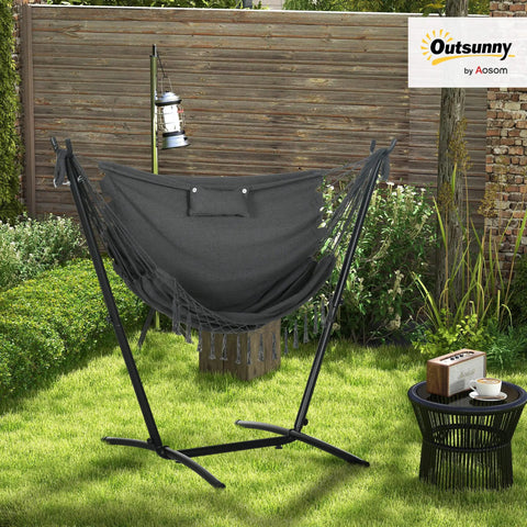 Outdoor setting featuring Patio Hammock Chair With Stand For Outdoor Chill And Cozy Lounging Heavy Duty Hanging Swing With Side Pocket And Headrest Weatherproof Fabric Boho Tassels Easy Assembly Dark Gray.