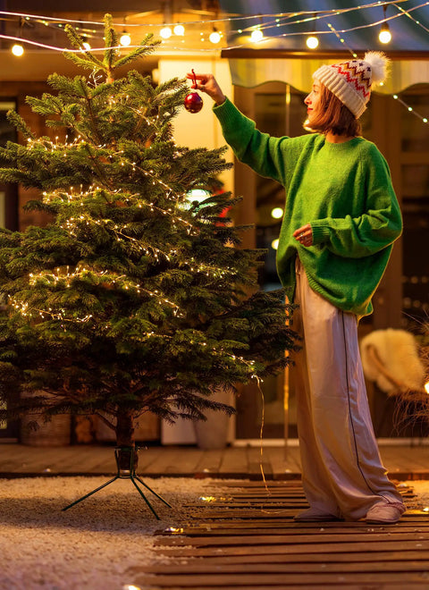 Person decorating Christmas tree with Battery Operated Fairy Lights 10Ft 120 LED Firecracker String Lights With 6 Hour Timer Waterproof Silver Wire.