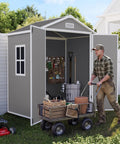 Man organizing tools inside a Spacious 6x4 Outdoor Storage Shed With Floor For Bikes Tools And Gear in gray and white.