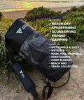 Collapsible Mesh Snorkel Bag for Long Fins with Top Opening on sandy beach, strap visible, marine-grade material, grass background.