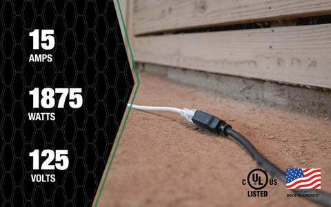 Hardcore 100 Foot Black Outdoor Extension Cord 10 Gauge 3 Conductor shown plugged in the dirt, UL listed, Made in USA