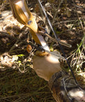 Traditional Arrow Holder With Vented Retainer For Archery Gear mounted on recurve bow in forest setting