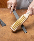Person using 10 Inch File Card And Brush With Wood Base Grip For Hand Files And Rasps Keeps Teeth Clean And Debris Free Easy Grip Tool For Metalworking And Shop Maintenance