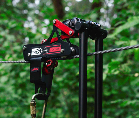 All In One Zip Line Trolley Pro X With Brake Bundle featuring heavy duty carabiner and lanyard on cable setup in a forest setting.