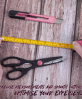 39 Piece Pink Household Tool Set With Storage Case For Home DIY Projects Includes Hammer Pliers Screwdrivers Tape Measure And More Durable Chrome Plated Tools For Quick Fixes And Everyday Repairs image showing tape measure, scissors, and utility knife on wooden surface.