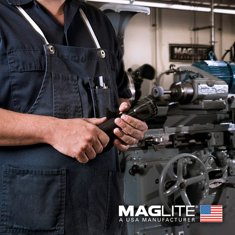 Person in workshop holding 3 Cell D Flashlight With Water Resistant Body, Black Finish, for Outdoors and Emergencies