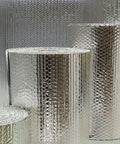 Double Sided Reflective Aluminum Foil Insulation Roll One Quarter Inch Thick R8 Double Poly Air For Walls Attics Ducts Windows HVAC Garages 24 by 100 Inches Heavy Duty Energy Saving Heat Shield displayed in rolled form on a flat surface.