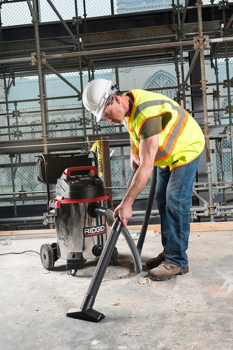 Worker using 16-Gallon Stainless Steel Wet Dry Shop Vacuum With Cart, Pro Hose, Drain And Blower Port, 6.5 Peak HP Motor, Red on site