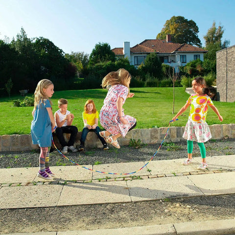 Children playing outdoors with Double Dutch Jump Rope Set 16.4 Ft 2 Pack With Beaded Plastic DIY Segmented Rope, extra handles included.