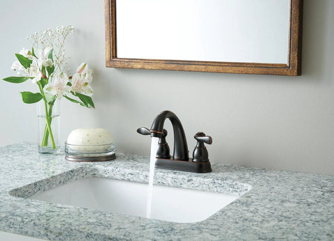 Centerset Chrome Bathroom Faucet For 4 Inch 3 Hole Vanity Sink With Metal Push Pop Drain Assembly And No Fuss Easy DIY Install Model B2596LF Built To Last, installed on a marble countertop next to flowers and soap.