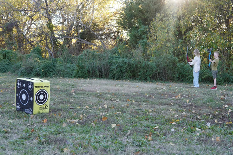 Children practicing archery with Travel Pro Portable Layered Foam Archery Target With Welded Core Technology in a field