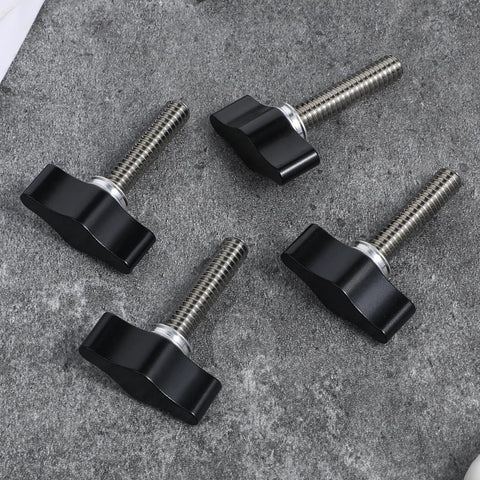 Four Piece Heavy Duty Stainless Steel Wing Knob Set Featuring Quarter Inch Coarse Thread And Rugged Black Grip on a gray surface.