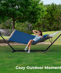 Woman relaxing in a 12Ft Two Person Quilted Outdoor Hammock With Stand Detachable Pillow And Bamboo Spreaders Chill Out Hammock in a backyard