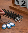 Hand holding 50 Pack Wire Keychain Cables Nylon Coated Stainless Steel Loop for Luggage Tags 2mm Thick 7.8 Inches Long Black Durable Design