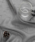Gray Faux Linen Sheer Curtains Set, fabric detail with textured design, pine cone and glass mug placed on top.