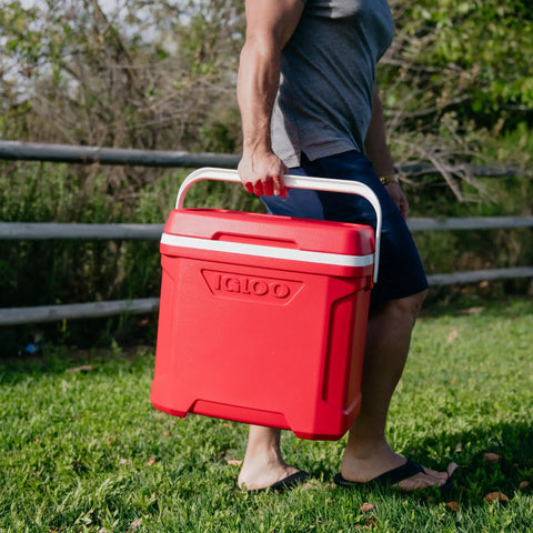 Person carrying Profile II 16 Quart Red Cooler With Fold Flat Bail Handle, Cool Riser Technology, in outdoor setting