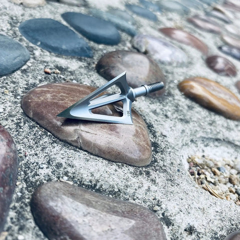 Fixed Blade Hunting Broadhead 100 Grain 420 Stainless Steel Three Razor Sharp Blades Vented Design on pebbles