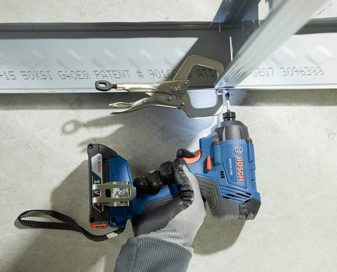 Person using 18V 1/4 Inch Hex Impact Driver Kit With 2Ah Battery on metal beam, showing high torque and compact design.