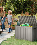 50 Gallon Outdoor Storage Box Weatherproof Resin Deck Box with Reinforced Lid used as patio bench, open with garden tools inside.