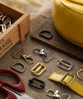 Killer Metal Bag Hardware Kit Featuring Twenty One D Rings Fourteen Swivel Snap Hooks And Twenty One Slide Buckles For Leather Stitching And Purse Making Crafts with assorted D rings and swivel snaps.