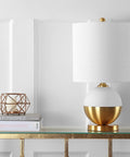 White And Brass Gold Ceramic Table Lamp With White Linen Drum Shade on modern glam console table.