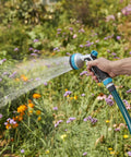 Heavy Duty Front Control Garden Hose Nozzle With 8 Preset Spray Patterns in use watering vibrant garden flowers with ergonomic handle