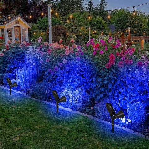 Blue Solar Spotlight Kit Outdoor Waterproof Garden Lights illuminating flowers at night in a garden setting with trees and lights