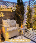 Two Pack Battery Operated Fairy Lights With Remote illuminating outdoor garden corner with chair and floral decor, 132 ft copper wire.