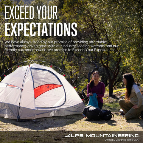 Two people sitting near a pitched ALPS Mountaineering tent in a forested campsite, enjoying a sunny day outdoors.