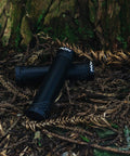 Lock On Clamp Mountain Bike Handlebar Grips With Lightweight Ergonomic Design for 22mm Bars placed on forest floor