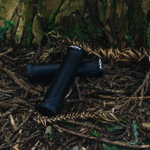 Lock On Clamp Mountain Bike Handlebar Grips With Lightweight Ergonomic Design for 22mm Bars placed on forest floor