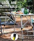 Foldable Outdoor Picnic Camping Table With Adjustable Height Aluminum Legs And Roll Up Top, set up at a campsite with chairs.